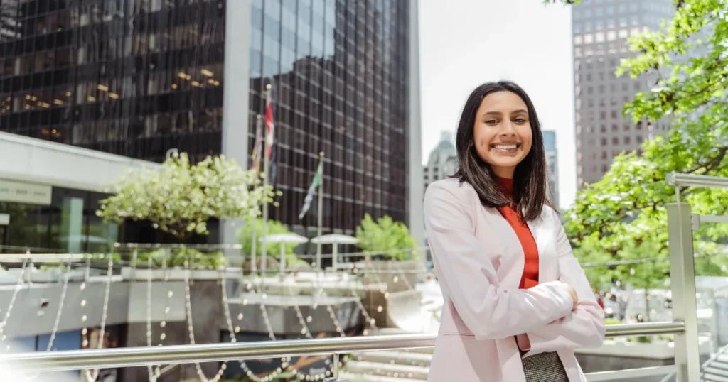 Pakistani professional holding a UK work visa with British flag and cityscape in the background.