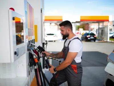 A petrol station attendant refueling a car at a service station in Birmingham.